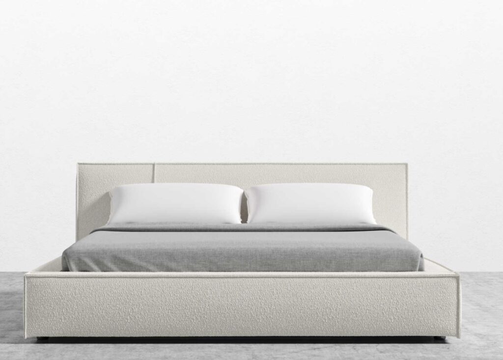 lit sur un mur blanc et un plancher gris