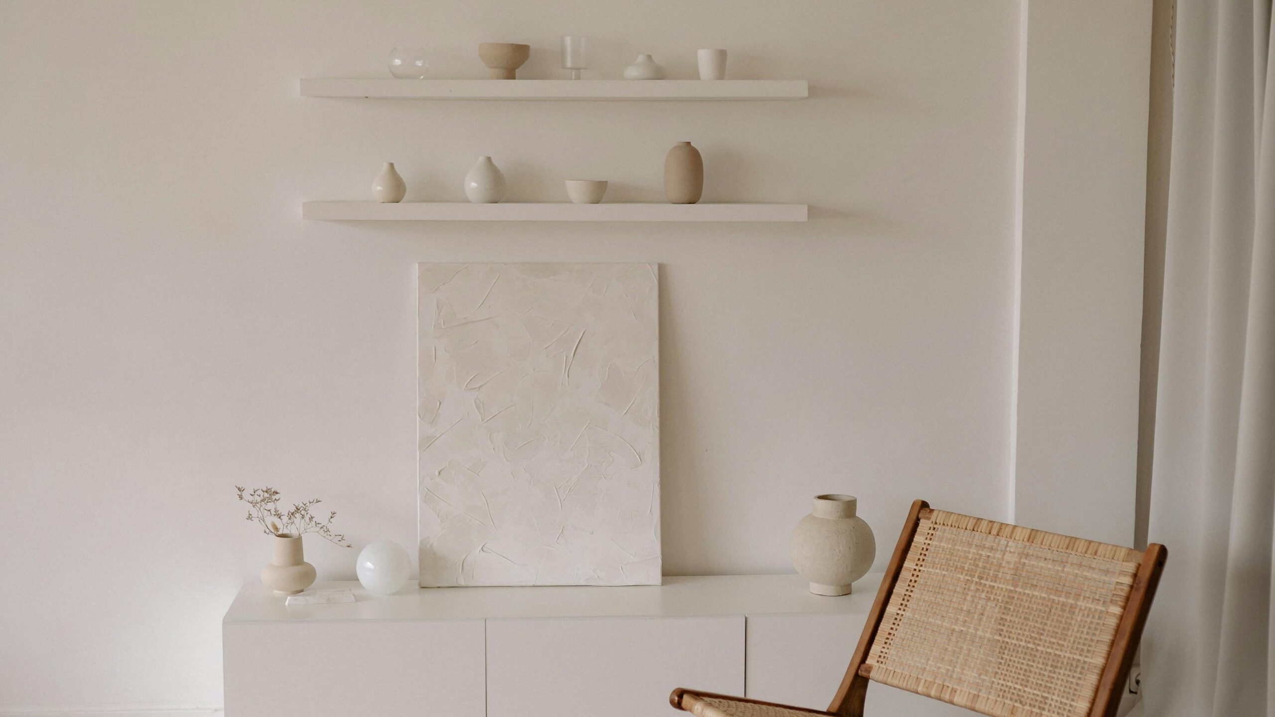 Chaise d'osier devant étagère blanche crème
